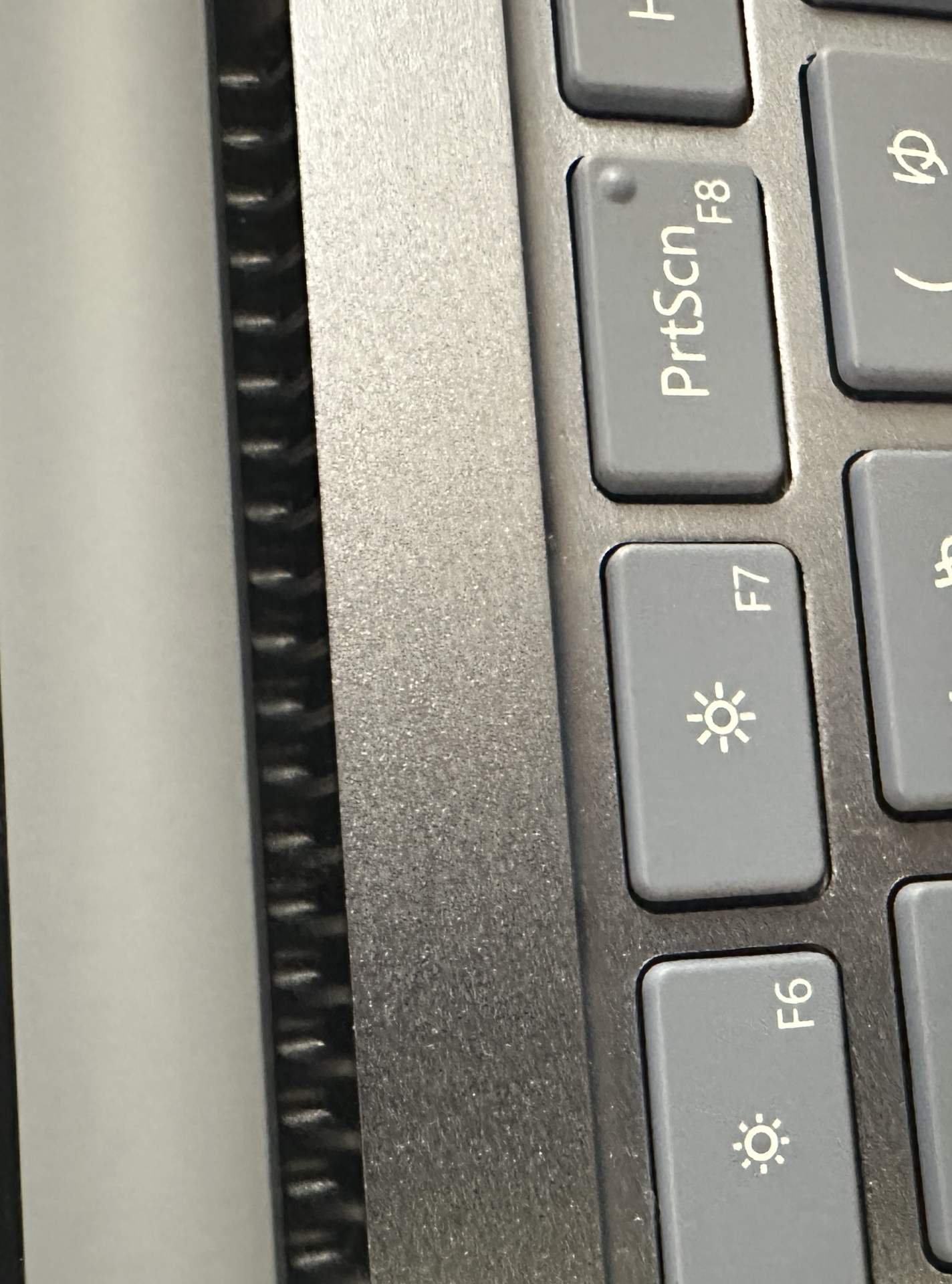 ノートパソコンを開いた状態。画面とキーボードのあいだ、ヒンジ側に細い通気口が並んでいる