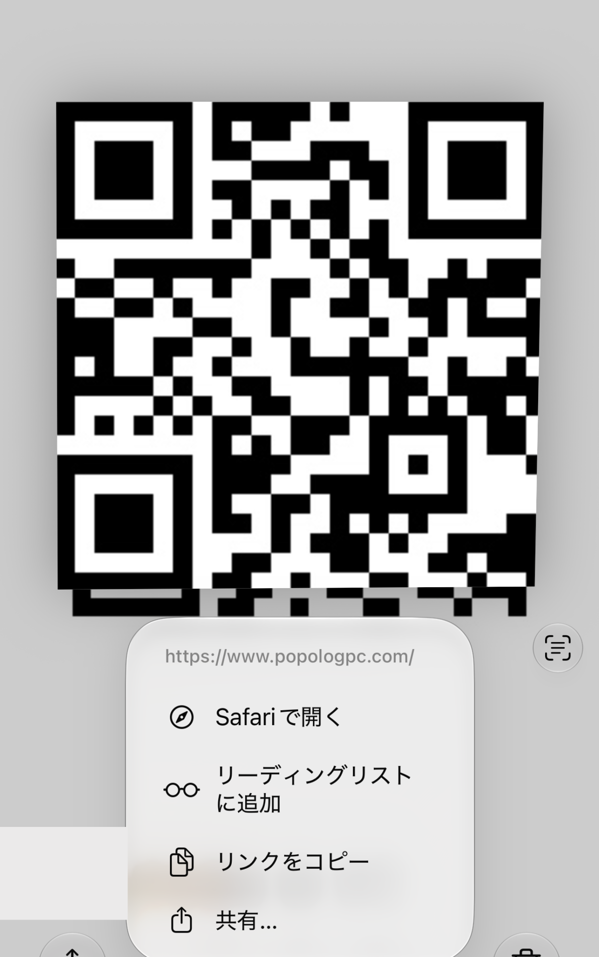 iPhoneの写真アプリで、QRコードの画像を長押ししたところ。QRコードの下に、リンクの https://www.popologpc.com/ と、「Safariで開く」「リーディングリストに追加」「リンクをコピー」「共有…」のメニューが出ている。